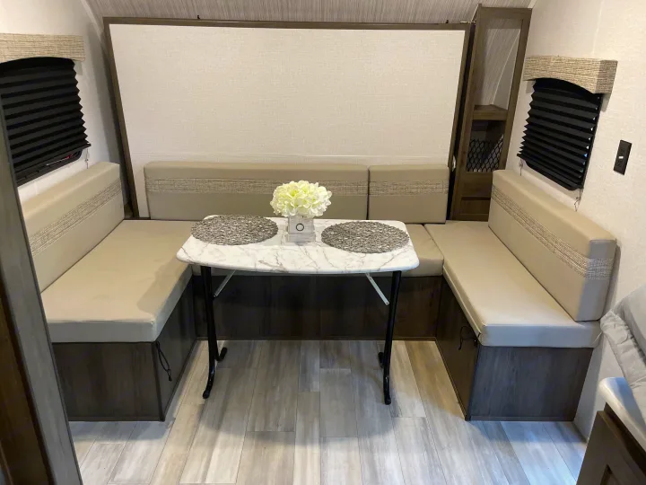 Enjoy meals in this bright rv rental dinette featuring U-shaped seating, a marble-look table, and window blinds.. Coachmen Viking 162RBU 2022