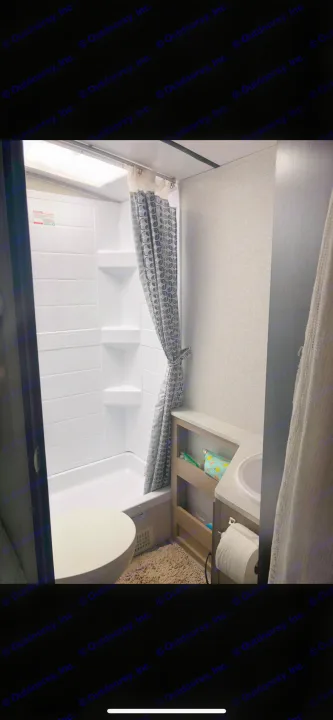 Efficient bathroom in an RV rental, featuring a shower/tub, toilet, and sink with storage. Ready for your adventure.. Forest River Legend 2019