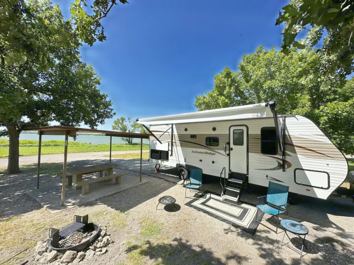 Enjoy your RV rental getaway! This scenic campsite features an RV, lakeside view, picnic area, fire pits, and outdoor seating.. Starcraft Autumn Ridge 2022