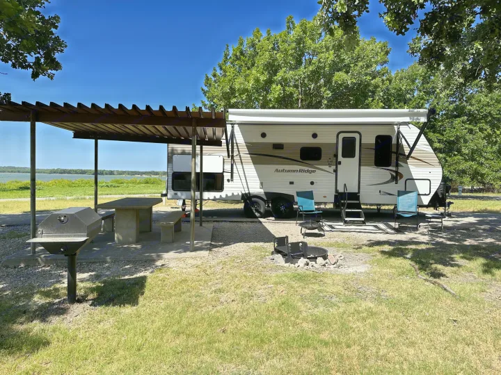 Enjoy lakefront camping with this spacious RV rental. Features a covered picnic area, grill, & fire pit for ultimate outdoor relaxation.. Starcraft Autumn Ridge 2022