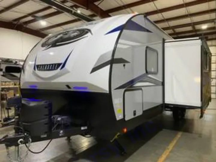 Front view of a white travel trailer RV with blue accents and slide-out extended, perfect for rv rental adventures.. Forest River Cherokee Alpha Wolf 2022