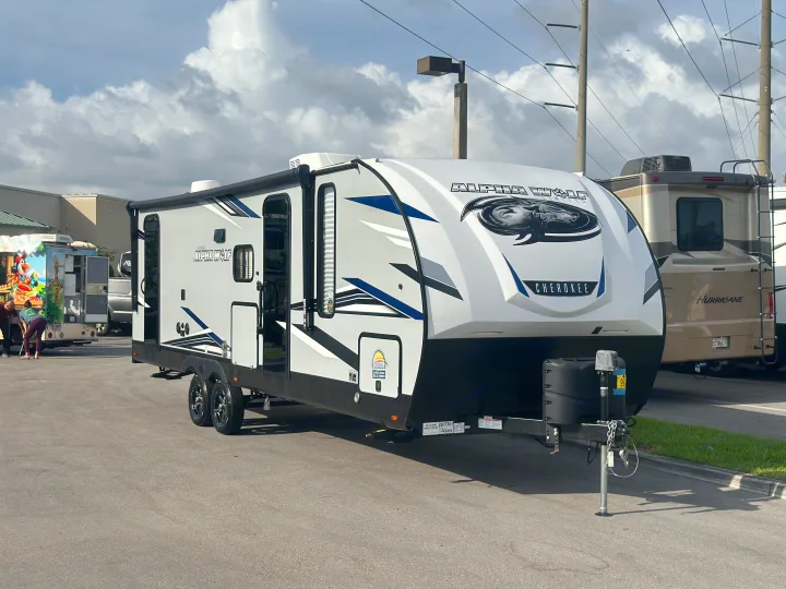 Modern Alpha Wolf Cherokee travel trailer, perfect for RV rental, displayed on a paved lot with other recreational vehicles.. Forest River Cherokee Alpha Wolf 2022