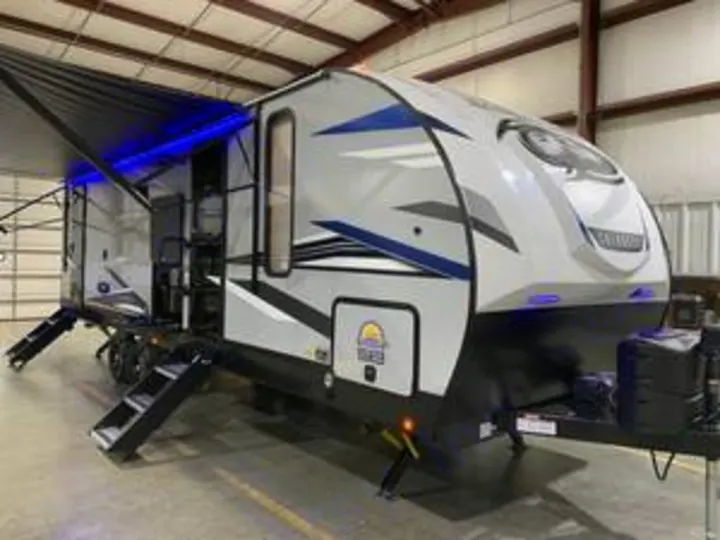 Explore this modern travel trailer RV rental, featuring an extended awning with blue LED lights. Perfect for your next camping trip!. Forest River Cherokee Alpha Wolf 2022