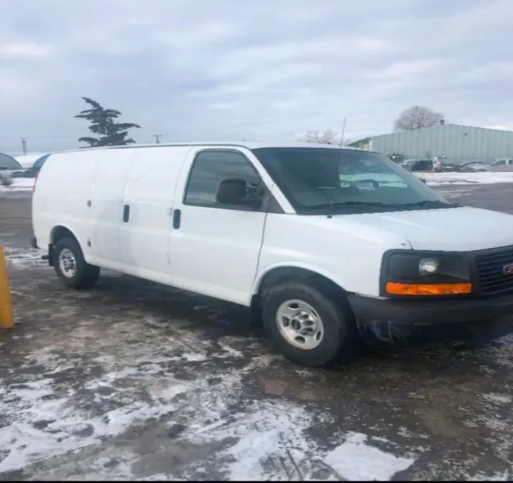 A white cargo van on snowy ground, versatile for utility or RV conversion. Explore our vehicle rental, including RV rental options.. Gmc Savanna 2013