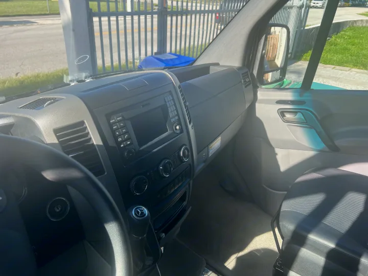 Driver's view inside a clean Mercedes-Benz van, a common RV rental. Features dashboard, steering wheel, and passenger seat.. Mercedes Sprinter 2016