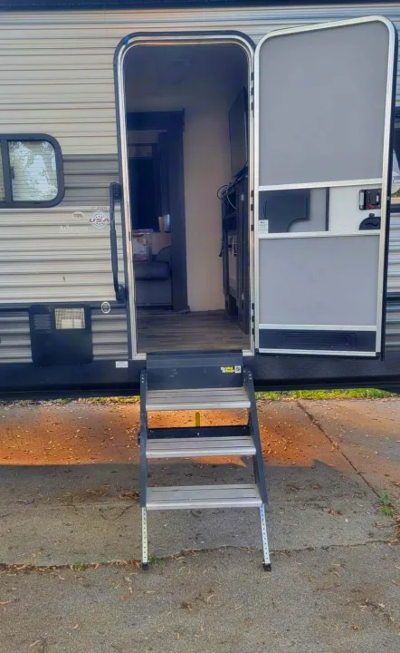 Open side door of an RV rental with four steps leading inside, revealing its welcoming living space. Your adventure awaits!. Forest River Salem 2019