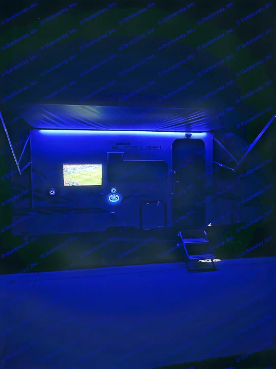 "BLACK LABEL" luxury RV rental: sleek, blue-lit interior with entertainment screen showing a sports game.. Forest River Wolf Pup 16 BHS Black Label 2023