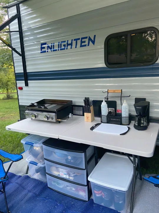 RV rental campsite kitchen: griddle, coffee maker, storage on folding table. Perfect outdoor cooking setup.. Gulf Stream Enlighten 2021