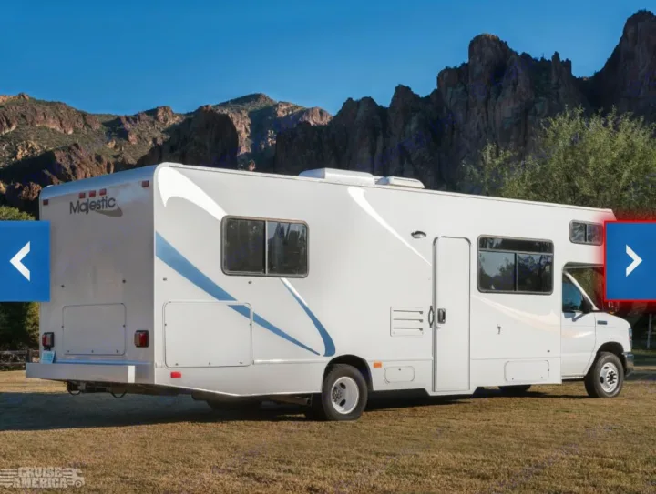 A white Majestic Class C RV rental is parked on a grassy field with rugged mountains and a clear sky in the background, ready for adventure.. Thor Majestic 2018
