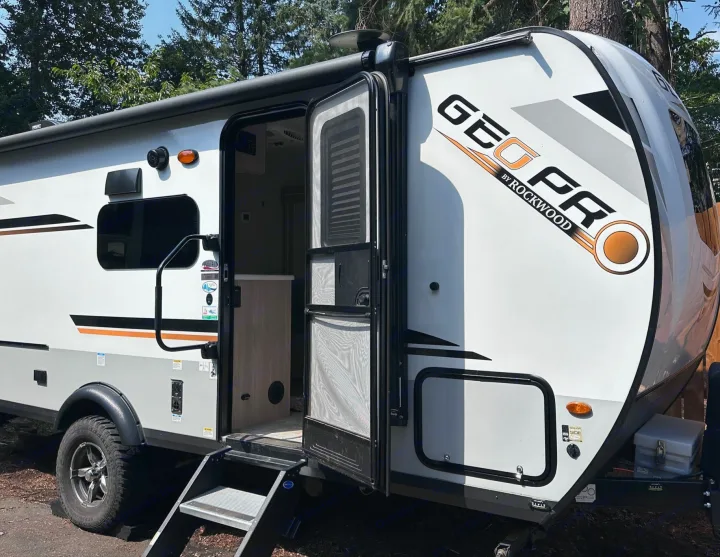 Geo Pro travel trailer ready for your rv rental adventure, with its door open revealing the interior.. Forest River Rockwood Geo Pro 2021