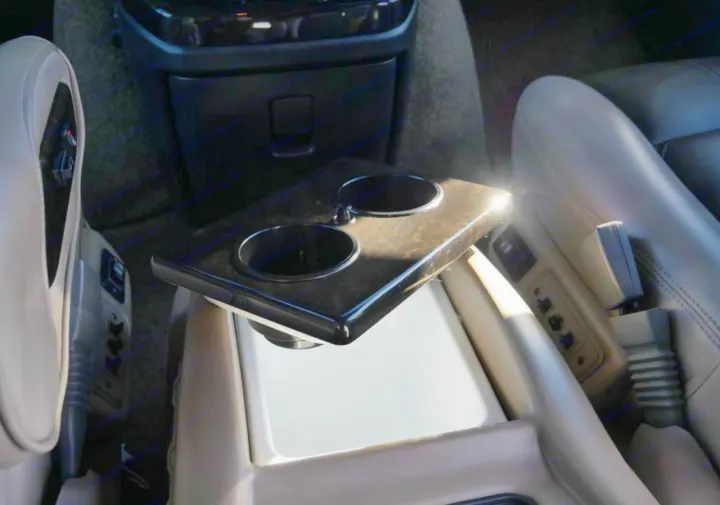 RV rental's luxurious interior: plush leather captain's chairs and central console with wood-grain cup holders for comfort.. Chevrolet 2500 2019