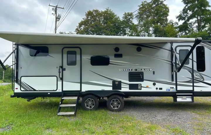 Discover adventure with this gray White Hawk RV rental travel trailer featuring an extended awning and convenient steps.. Jayco White Hawk 2021