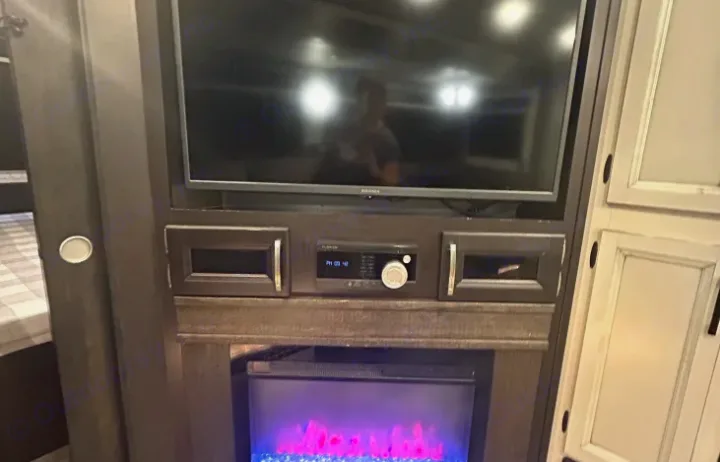 RV rental features: built-in entertainment center with TV, stereo system, and cozy electric fireplace for comfort.. Jayco White Hawk 2021