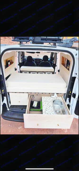 Compact RV rental: White camper van interior with a cozy bed, pull-out kitchen (stove & sink), and built-in storage.. Dodge Dodge promaster city 2016