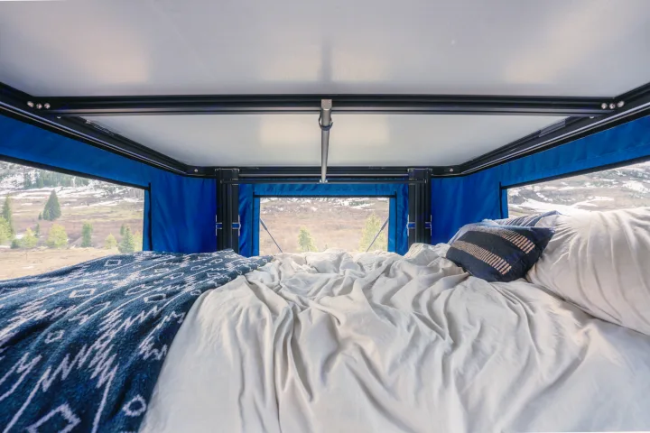 Enjoying an RV rental! A cozy bed inside a rooftop tent offers stunning nature views. Ideal for camping and travel.. Toyota Tacoma 2022