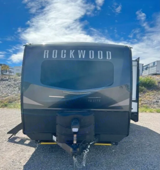 Front view of a grey Rockwood travel trailer, a spacious RV rental ready for outdoor adventures.. Forest River Rockwood Ultra Lite 2023