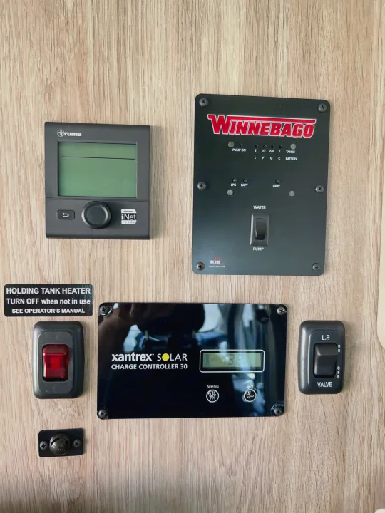 RV rental control panel wall: Truma heater, Winnebago monitor, Xantrex solar charger, and RV tank/water controls.. Winnebago Solis 2023