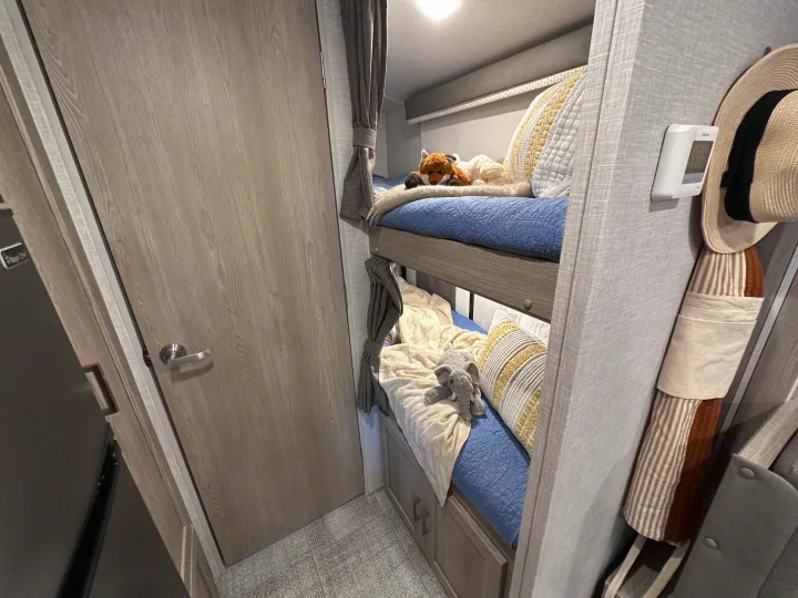 This RV rental features cozy bunk beds with stuffed animals, privacy curtains, and a convenient thermostat.. Forest River Rockwood Geo Pro 2021