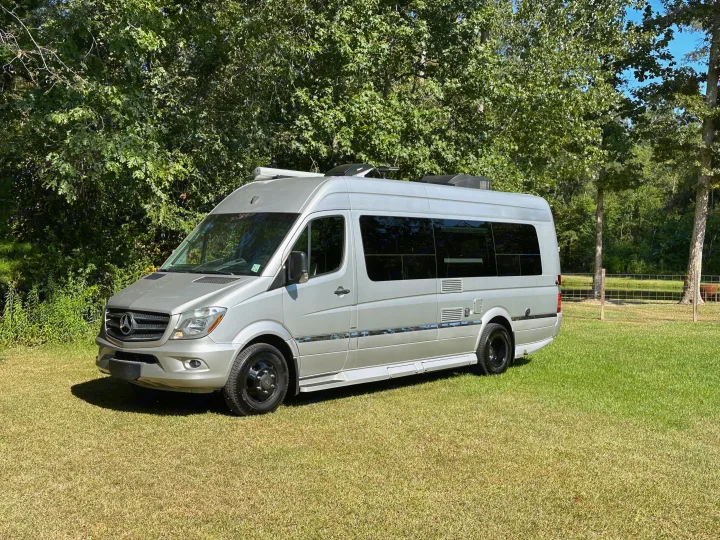 Silver Mercedes-Benz Sprinter RV rental parked on green grass, ready for your next camper van adventure.. Winnebago Era 2017