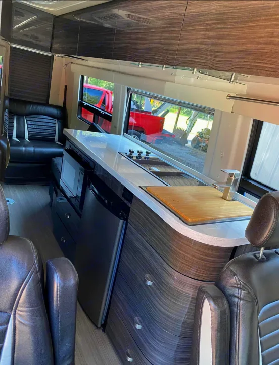 Explore this RV rental's luxury interior: modern kitchen with sink, stovetop, fridge, microwave & cozy seating.. Winnebago Era 2017