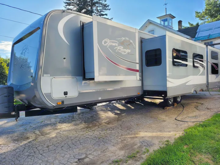 Large gray Open Range Roamer recreational vehicle with slide-outs extended, ideal for an rv rental experience.. Highland Ridge RV Roamer 2016