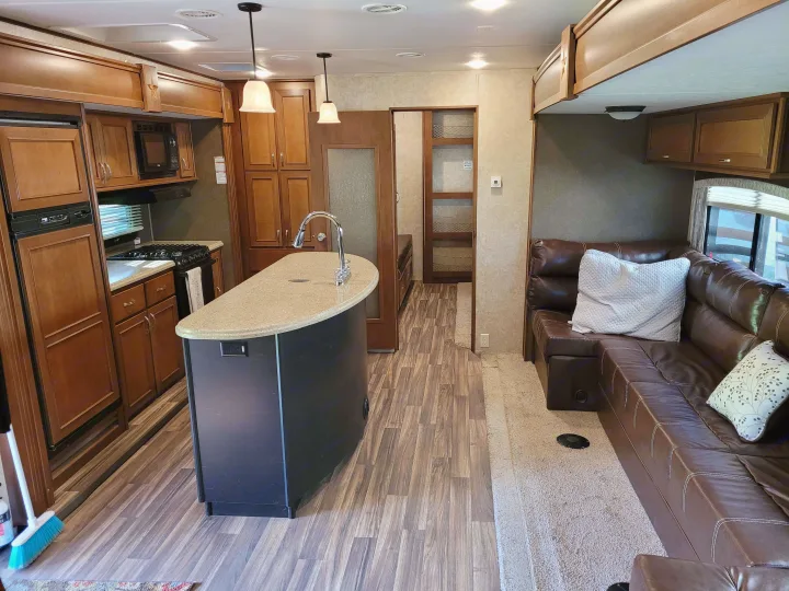 This rv rental features a spacious interior with a full kitchen, island, and comfortable living area.. Highland Ridge RV Roamer 2016