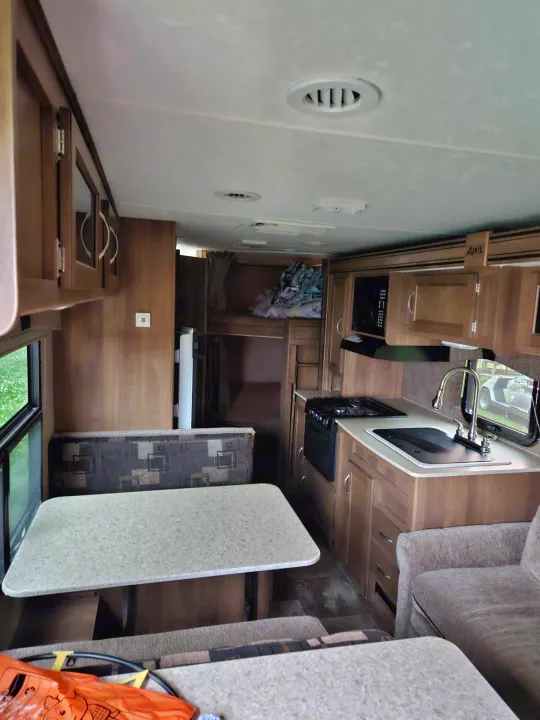 Spacious RV rental interior with kitchen, dinette, bunk beds, and living area. Perfect for family trips.. Coachmen Apex 50th Anniversary 2015