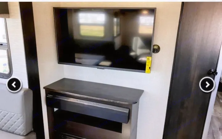 Comfortable RV rental interior: A wall-mounted TV, media console, and cozy seating area are featured in this modern living space.. Highland Ridge RV Range Lite 2022