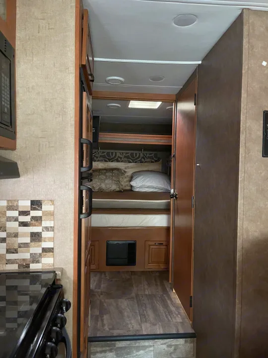 Inside an RV rental: view from the kitchen, through the hall, to bunk beds. Features include a tiled backsplash & ceiling lights.. Forester Forester Motorhome 2016