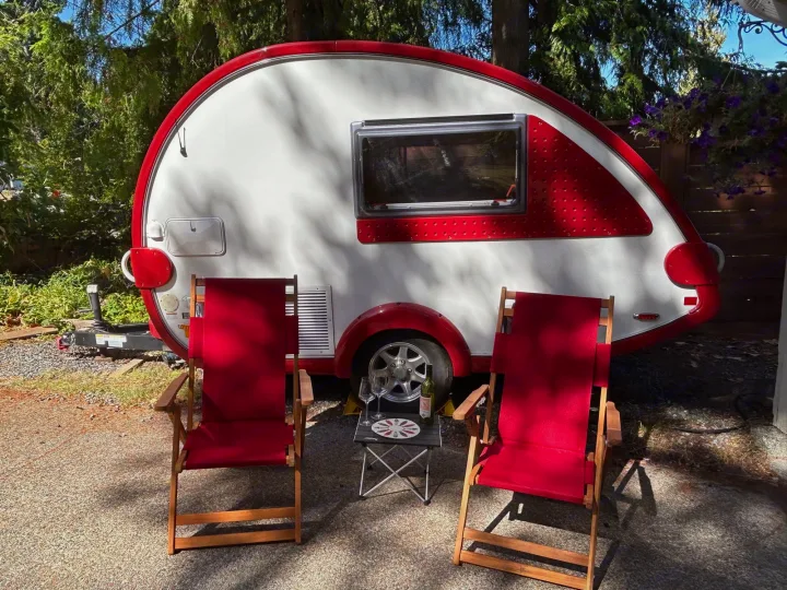 Experience an RV rental! A red and white teardrop trailer with two red chairs, a small table, and wine for relaxation.. T@B Q Floorplan Maxx Package 2016