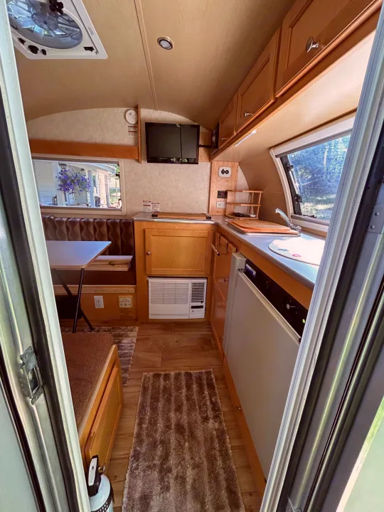 Cozy RV rental interior with a well-equipped kitchen, dining area, and overhead cabinets for a comfortable journey.. T@B Q Floorplan Maxx Package 2016