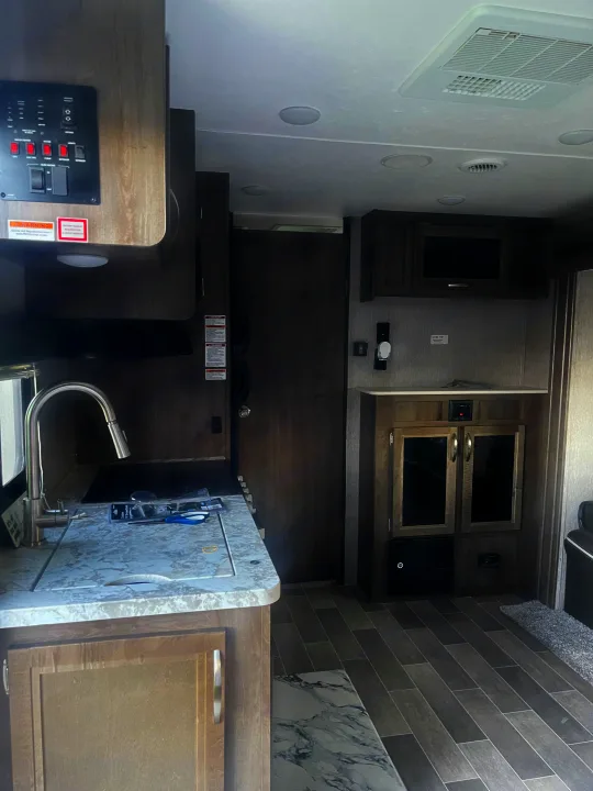 Spacious RV rental interior with a well-equipped kitchen, entertainment center, and comfortable living area.. Dutchmen Coleman Light 2019