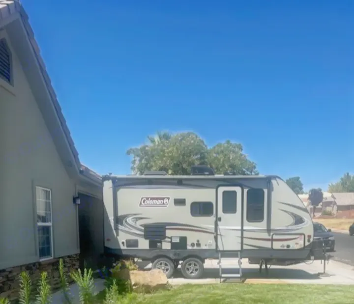 A spacious Coleman travel trailer, ideal for rv rental adventures, parked by a house on a sunny day. Great for outdoor recreation.. Dutchmen Coleman Light 2019