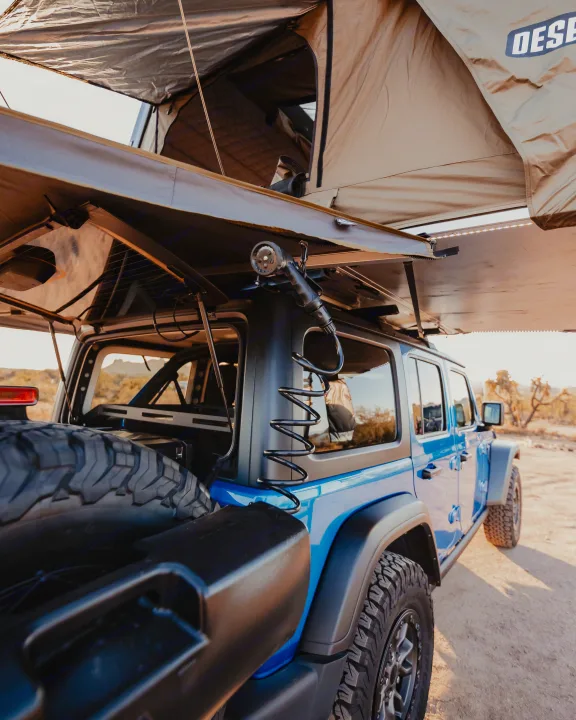 Get ready for off-road camping! Our RV rental, a blue Jeep with rooftop tent & shower, is ideal for outdoor adventures.. Jeep Wrangler 2022