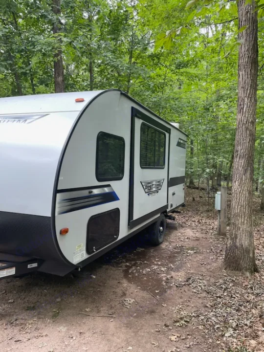 Primitive RV rental travel trailer set in a shaded, wooded campsite, ready for adventure.. Forest River Salem FSX 2020