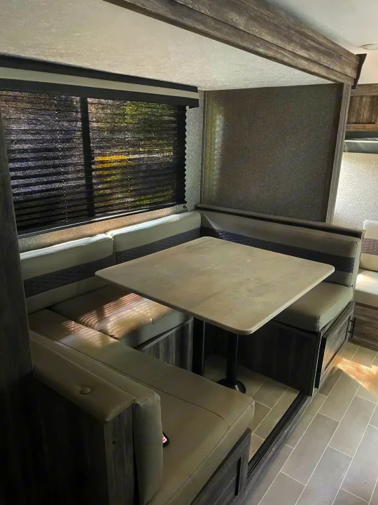 RV rental dinette: spacious interior with U-shaped booth seating, table, and window blinds.. Forest River Salem FSX 2020