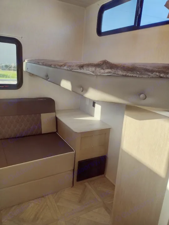 Cozy RV rental interior features a bunk bed, convertible sofa, and storage cabinetry. Ideal for travel comfort.. Forest River Salem Cruise Lite 2023
