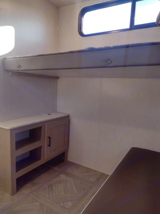 Inside an RV rental: a built-in bunk bed, compact storage unit, and window for natural light. Practical and cozy.. Forest River Salem Cruise Lite 2023
