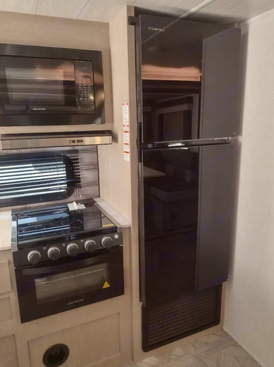 RV rental: Modern kitchen with Greystone microwave, oven, cooktop, and large Everchill refrigerator.. Forest River Salem Cruise Lite 2023