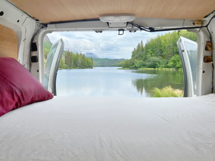 RV rental: Wake up to this serene lake and mountain view from a cozy bed in your van, doors open to nature.. Ford Econoline 150 1997
