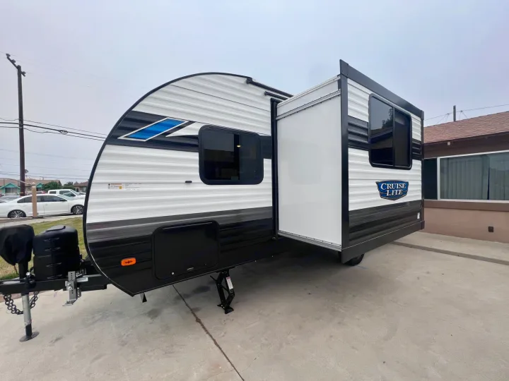 White and black travel trailer for RV rental, featuring an extended slide-out and front hitch assembly.. Forest River Salem Cruise Lite 2024