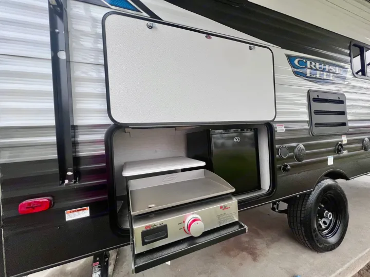 This RV rental's exterior hatch opens to reveal a built-in outdoor kitchen with a griddle and mini-fridge.. Forest River Salem Cruise Lite 2024