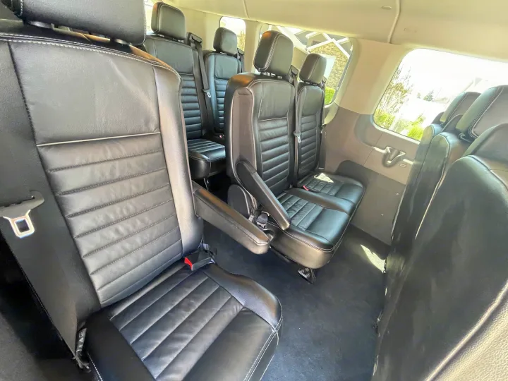 Spacious RV rental interior showcasing comfortable black leather passenger seats with white stitching, ready for your journey.. Ford Transit 350 XLT 2020