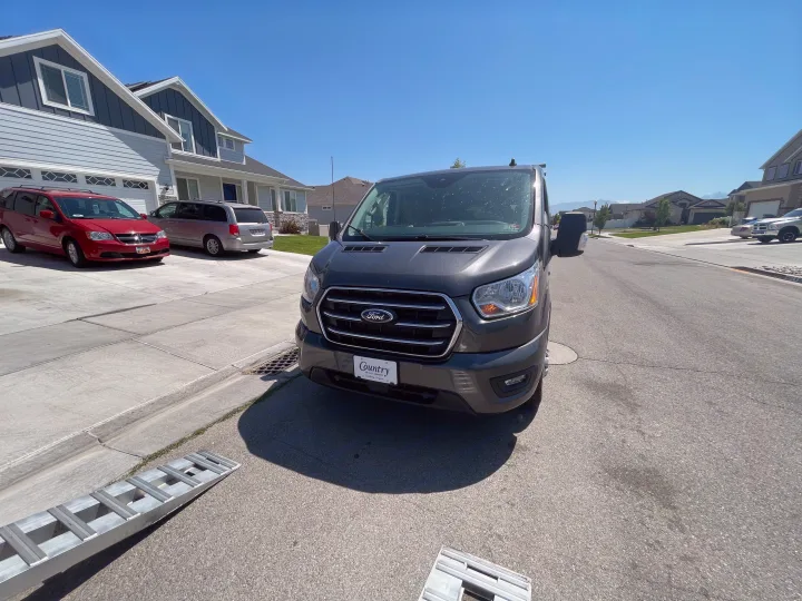 A dark grey Ford Transit van, useful for trips or an RV rental adventure, parked on a sunny street.. Ford Transit 350 XLT 2020