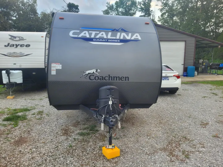 An RV rental setup: a gray Coachmen Catalina travel trailer on gravel, with a white Jayco RV behind it.. Coachmen Catalina Summit Series 7 2023