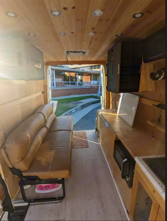RV rental: See inside this van conversion with wood walls, leather seating, built-in kitchen, and bright overhead lights.. Mercedes Benz Sprinter 2500 2014