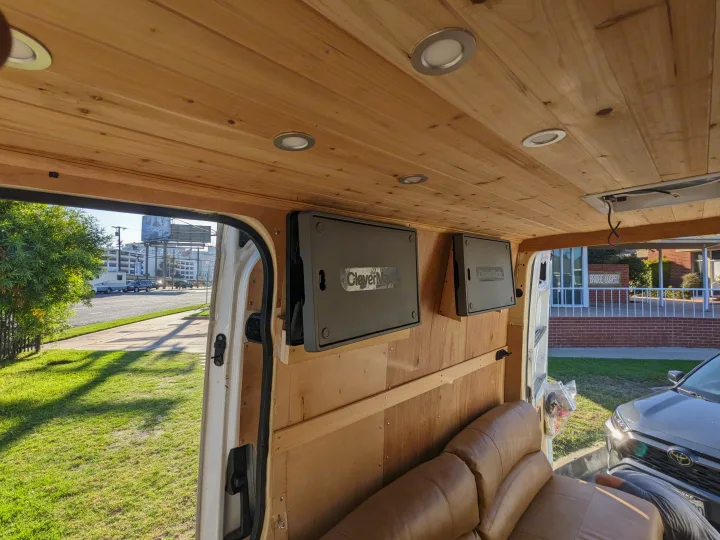 Custom van RV rental interior with a light wood ceiling, recessed lights, CleverMade wall storage, and brown leather seating.. Mercedes Benz Sprinter 2500 2014
