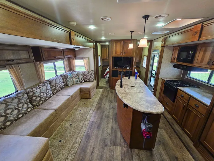 Spacious RV rental interior featuring a full kitchen, comfy sectional sofa, and modern amenities for your next adventure.. Open Range RV Light 2014