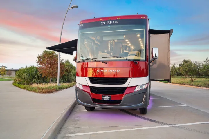 Luxurious red & white Tiffin Open Road Allegro RV rental, parked with slide-out & awning extended at sunset.. Tiffin Open Road 36UA 2023