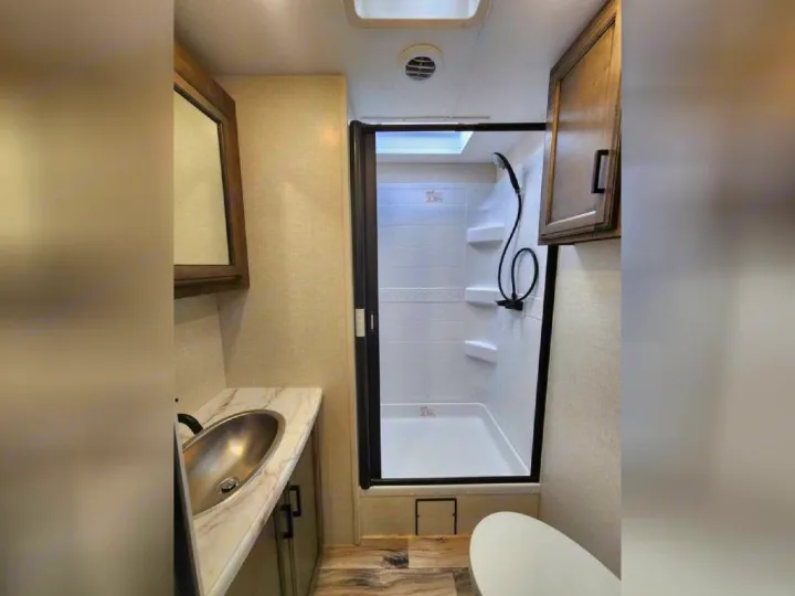Clean RV rental bathroom with modern shower, sink vanity, and toilet. Essential amenities for your road trip.. SportTrek STT333VFK 2023